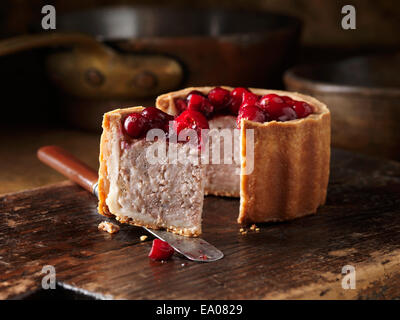 Weihnachten-Snack Cranberry gekrönt Pork Pie auf Schneidebrett Stockfoto