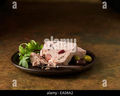 Weihnachten-Snack von geräuchertem Schinken Türkei & Hähnchen Terrine mit Preiselbeeren. Rakete gemischte Salatblätter mit grünen und schwarzen Oliven Stockfoto