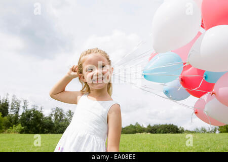 Mädchen mit einem Haufen Luftballons Stockfoto