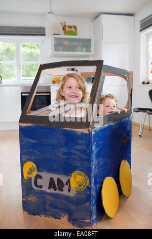 Zwei Mädchen in hausgemachten Spielzeugauto Stockfoto