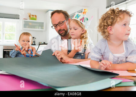 Familie machen Papier Kronen Stockfoto