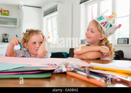 Zwei Mädchen am Tisch mit Papier und Stifte Stockfoto