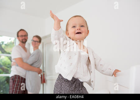 Baby mit Hand, Eltern im Hintergrund Stockfoto