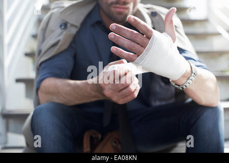 Bandagierung Hand Mann auf Treppe Stockfoto