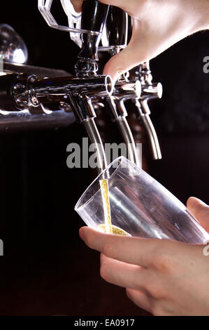 Alkohol-Konzeptbild. Barkeeper geben das Bier aus Spender. Stockfoto