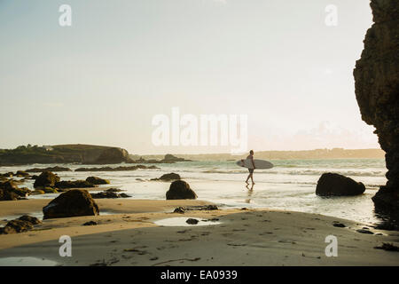 Reifer Mann zu Fuß in Richtung Meer, mit Surfbrett Stockfoto