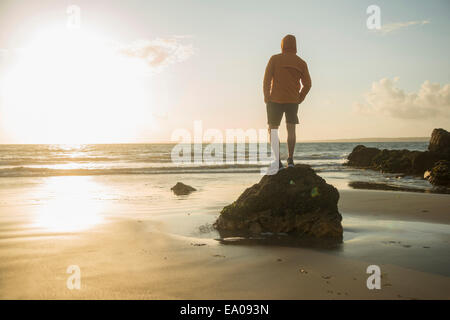 Reifer Mann, auf Felsen, Blick auf das Meer Stockfoto