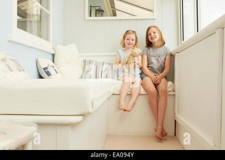 Porträt von zwei Schwestern, die im Urlaub Wohnung Veranda sitzen Stockfoto