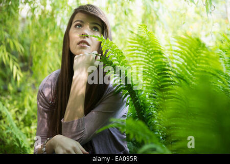 Frau kniend von fern Stockfoto