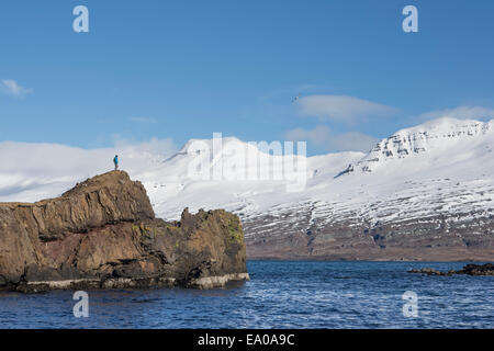 Mann steht am Rand der Insel, Island Stockfoto