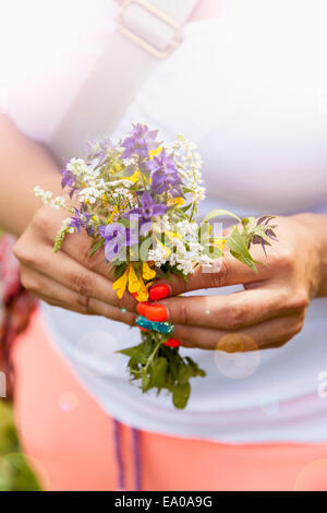 Junge Frau mit wilden Blumen Stockfoto