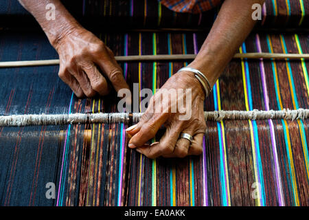 Eine Frau, die in ihrer Werkstatt webt - eine traditionelle, alternative Einkommensquelle im Dorf Lamagute, Lembata, Indonesien. Stockfoto