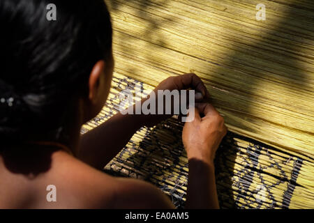 Eine Frau, die Muster vorbereitet, bevor sie in einer Werkstatt im Dorf Lamagute, Lembata Island, Indonesien, webt. Stockfoto