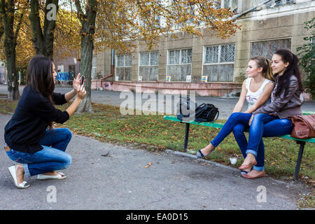 Eine junge Frau nimmt ein Foto ihrer Freunde in Odessa, Ukraine Stockfoto