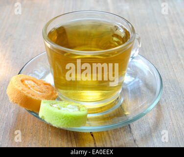 Tasse Tee und Roll Kuchen auf Holz Hintergrund. Stockfoto