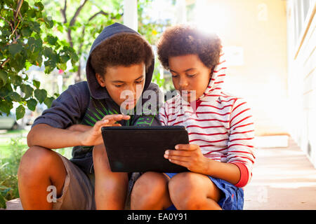 Zwei Brüder mit Touchscreen auf digital-Tablette im Garten Stockfoto
