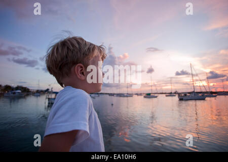 Junge auf Segelboot Blick auf das Meer bei Sonnenuntergang Stockfoto