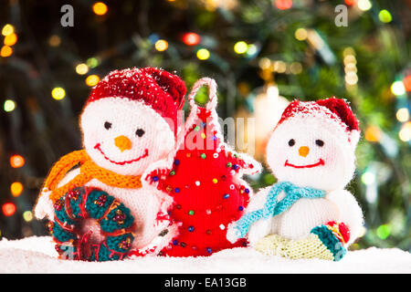 Gestrickte Schneemänner und handgemachte Weihnachtsbaum - Wohnaccessoires im Schnee Stockfoto