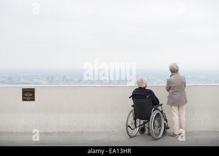 Rückansicht des älteren Menschen im Rollstuhl und seine Frau, Blick auf die Stadt vom Balkon Observatory Griffith Park Los Angeles anzeigen Stockfoto