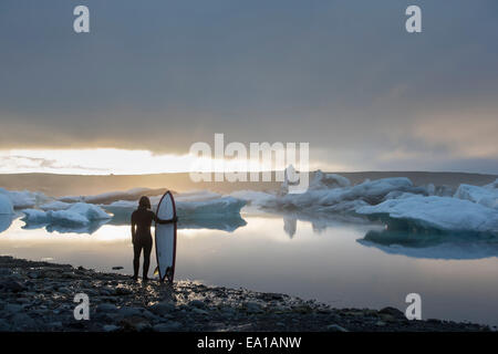 Frau mit Surfbrett, Jökulsárlón Gletscher Lagune, Skaftafell-Nationalpark, Island Stockfoto