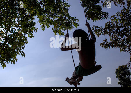 Narayangonj, Bangladesch. 5. November 2014. Spielt eine Mädchen auf einer Schaukel in Bangladesch unter Baum © Zakir Hossain Chowdhury/ZUMA Draht/Alamy Live News Stockfoto