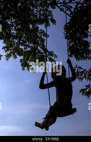 Narayangonj, Bangladesch. 5. November 2014. Spielt eine Mädchen auf einer Schaukel in Bangladesch unter Baum © Zakir Hossain Chowdhury/ZUMA Draht/Alamy Live News Stockfoto