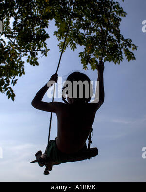 Narayangonj, Bangladesch. 5. November 2014. Spielt eine Mädchen auf einer Schaukel in Bangladesch unter Baum © Zakir Hossain Chowdhury/ZUMA Draht/Alamy Live News Stockfoto