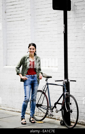 Frau stehend neben dem Fahrrad Stockfoto