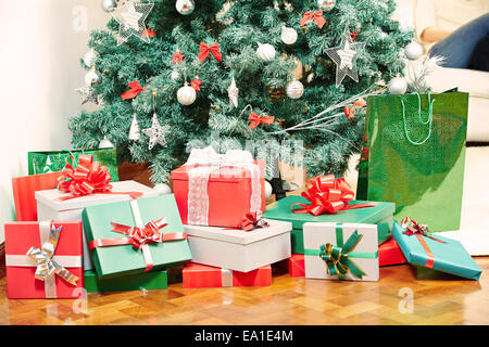 Viele Geschenke an Heiligabend unter den Weihnachtsbaum legen Stockfoto
