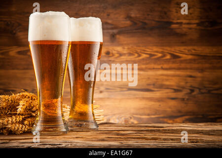 Flaschen Bier mit Ähren auf Holzbohlen Stockfoto