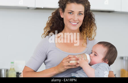 Attraktive Frau, die Verfütterung von Milch an baby Stockfoto