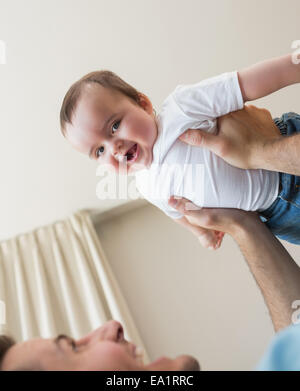 fröhliche Baby getragen von Vater Stockfoto