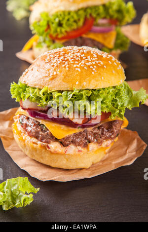 Leckere hausgemachte Hamburger serviert auf schwarzem Stein Stockfoto