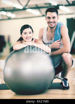 zwei lächelnde Menschen mit Fitness-ball Stockfoto