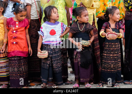 Kinder warten auf ankommende Gäste während einer traditionellen Begrüßungszeremonie in Lamagute Dorf, Lembata, Indonesien. Stockfoto