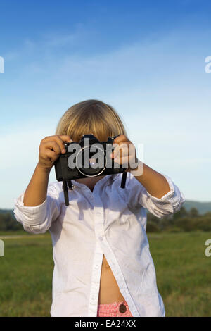 Jungen spielen im Freien mit Vintage Foto-Kamera Stockfoto