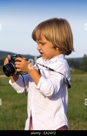 Jungen spielen im Freien mit Vintage Foto-Kamera Stockfoto