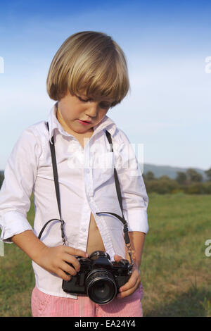 Jungen spielen im Freien mit Vintage Foto-Kamera Stockfoto