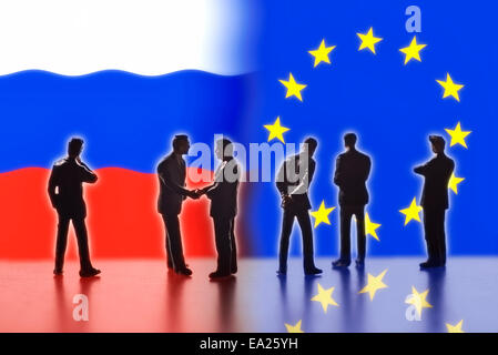 Modellfiguren als Symbol für Politiker stehen die Flaggen Russlands und der EU. Zwei von ihnen die Hand. Stockfoto