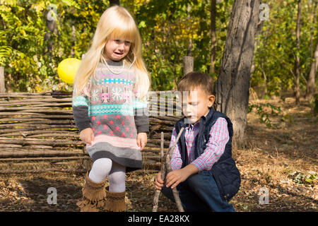 Jungen und Mädchen spielen zusammen im Freien im Wald eine kleine hölzerne Wigwam aus Zweigen und Ästen bauen, wie sie genießen eine Stockfoto