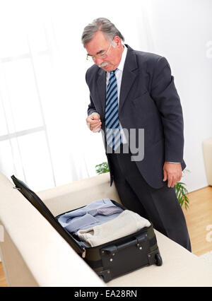 Senior woman Überprüfung des Koffers vor oder nach der Reise Stockfoto