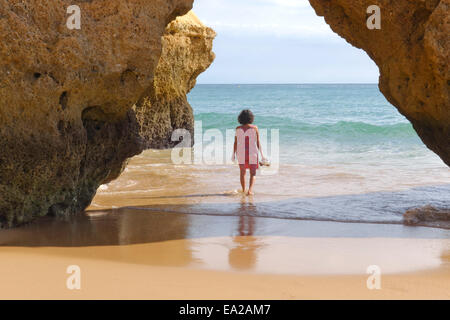 Frau zu Fuß ins Meer, Praia da Rocha, Felsstrand in Algarve in Portimao, Portugal. Stockfoto