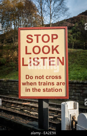 Eine Eisenbahn Fußgängerüberweg Zeichen Warnung bei einem alten Bahnhof in Goathland, England. Stockfoto