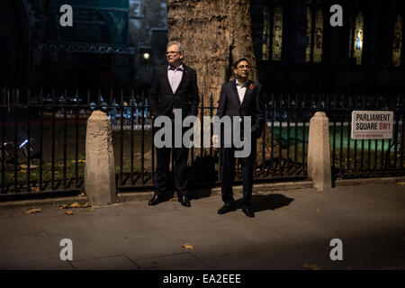 London, UK. 5. November 2014.  zwei Männer schauen auf Demonstranten in Parliament Square während der Millionen Maske Marsch auf Bonfire Night Credit: Piero Cruciatti/Alamy Live News Stockfoto