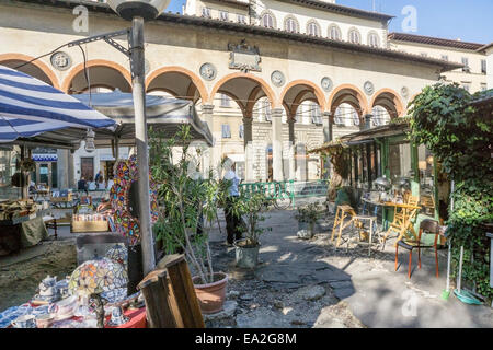 Blick auf charmante ad-hoc-Stände der Piazza dei Ciompi Flohmarkt gegen elegante Loggia del Pesce von Giorgio Vasari entworfen Stockfoto