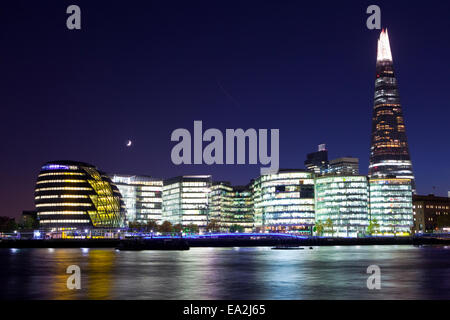 Ein Blick in der Abenddämmerung von den modernen Gebäuden entlang dem Südufer der Themse.  Die Gebäude umfassen die Scherbe und Rathaus. Stockfoto