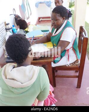 Kyetume, Uganda. 28. Oktober 2014. Nurse Margret Nanyonga (r) sorgt für einen HIV positiven Patienten im Gesundheitszentrum in Kyetume, Uganda, 28. Oktober 2014. Er lebt seit 1998 mit HIV. Seine Frau starb im Jahr 2003 von ihm. An der Kyetume Health Center, 20 Kilometer östlich von Kampala betreut sie rund 2000 Patienten. 900 von ihnen HIV-positiv sind und mit antiretroviralen Medikamenten behandelt werden. Foto: HENRY WASSWA/Dpa/Alamy Live News Stockfoto