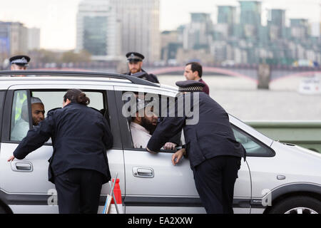 Metropolitan Police Officers auf Westminster Bridge, London zu stoppen nach dem Zufallsprinzip einen Wagen mit orientalischen Männer als Teil einer routinemässigen Sicherheitsoperation versuchen zu stören und Abschreckung terroristischen Aktivitäten in London.  Die Insassen des Autos wurden keine kriminellen Aktivitäten beteiligt und weiter auf ihrer Reise kurz danach. Stockfoto