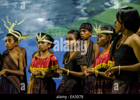 Kinder singen für Gäste bei einem traditionellen Begrüßungszeremonie in Lamagute Dorf, Lembata, Indonesien. Stockfoto