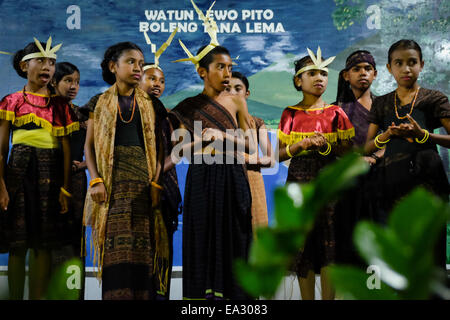 Kinder singen für Gäste bei einem traditionellen Begrüßungszeremonie in Lamagute Dorf, Lembata, Indonesien. Stockfoto